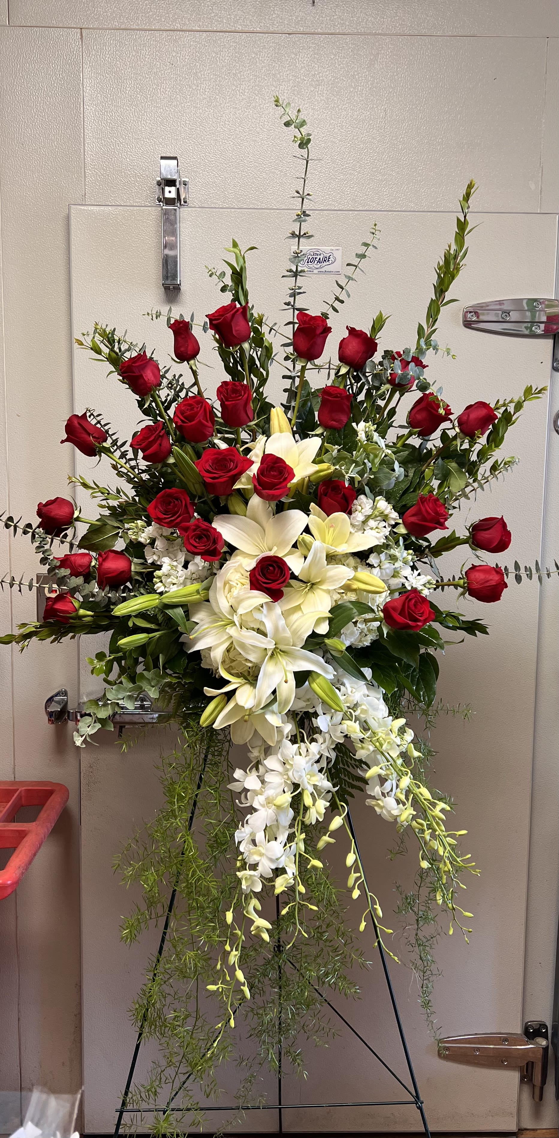 Standing floral spray with red roses, white lilies, and white orchids