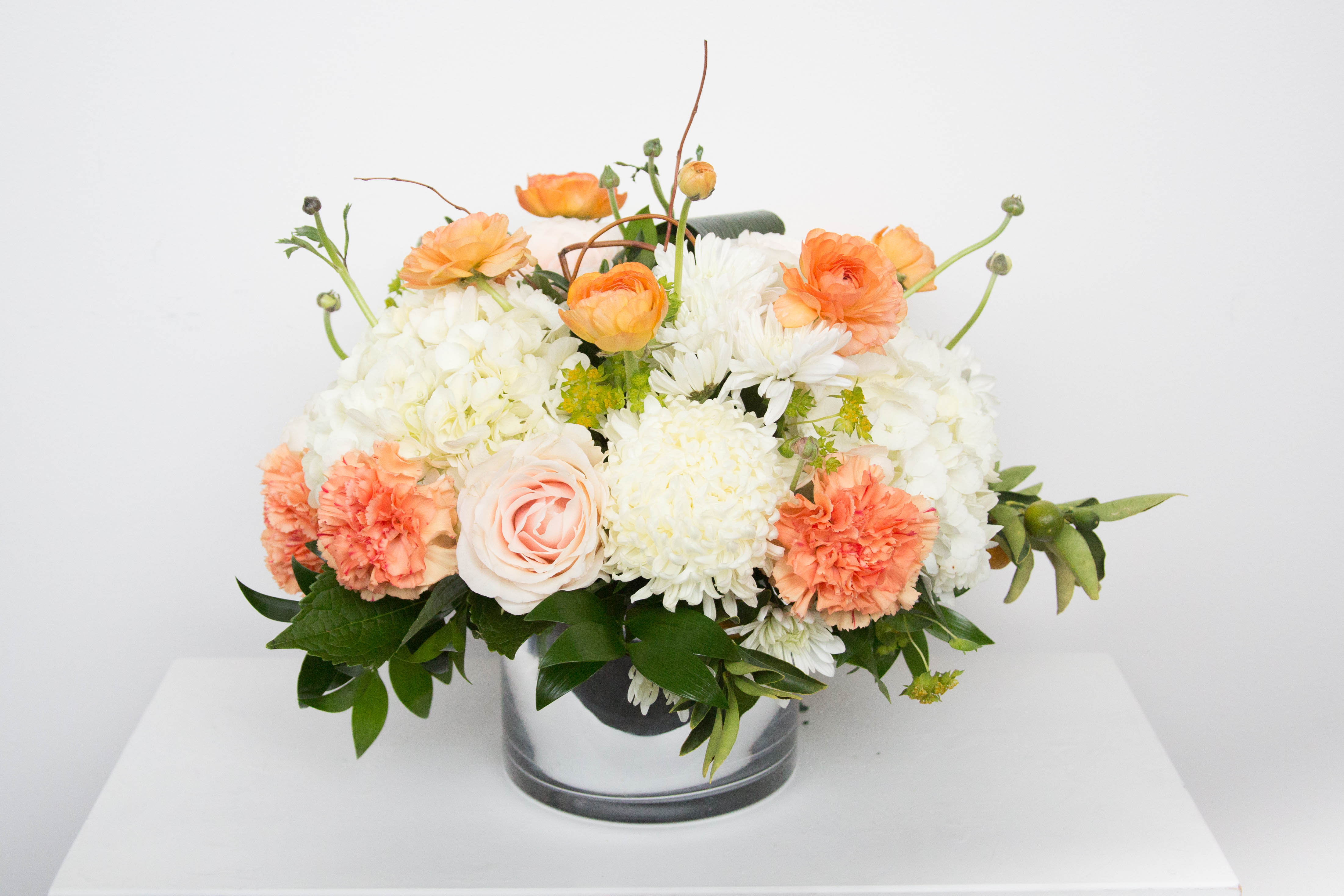 Peach and white floral arrangement in a clear glass vase