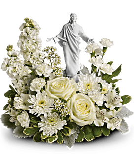 White floral arrangement with a small religious statue centerpiece