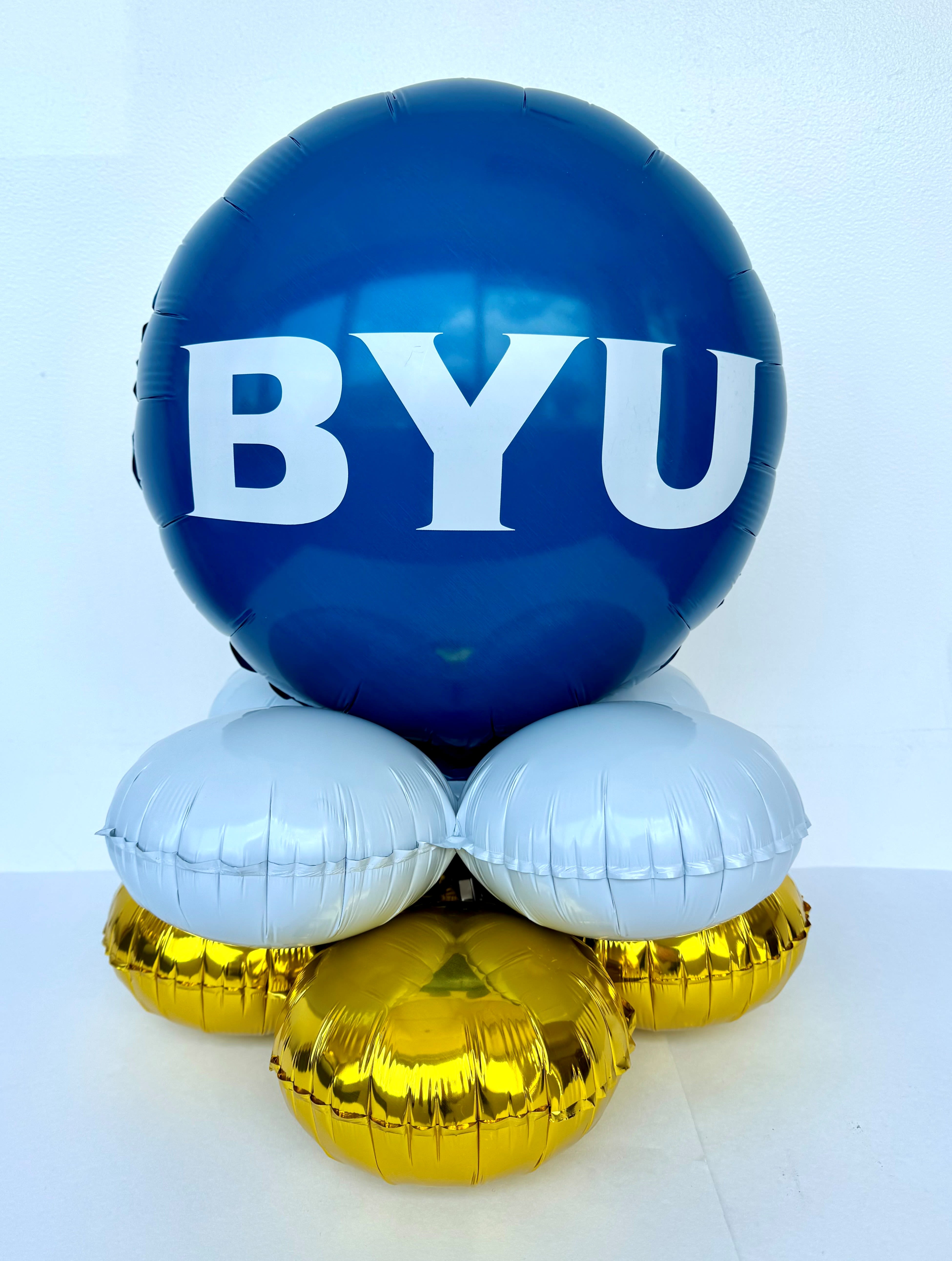 Blue BYU balloon arrangement with white and gold balloons