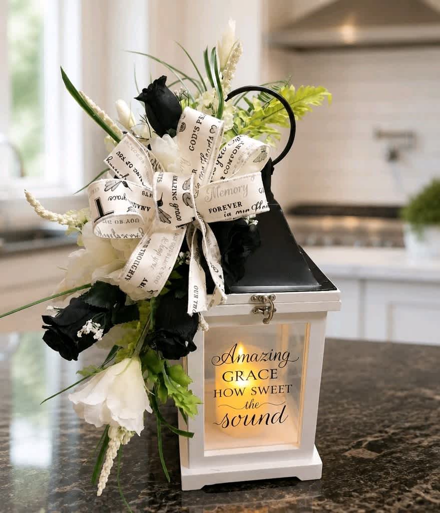 Black and white floral arrangement with a ribbon bow on a lantern