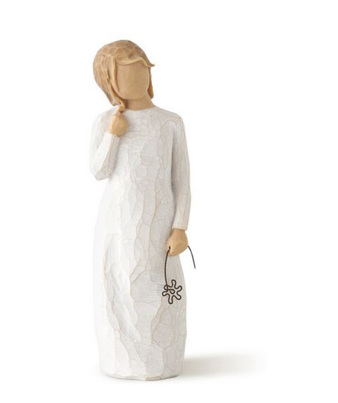 Wooden figurine in a white dress holding a small flower charm