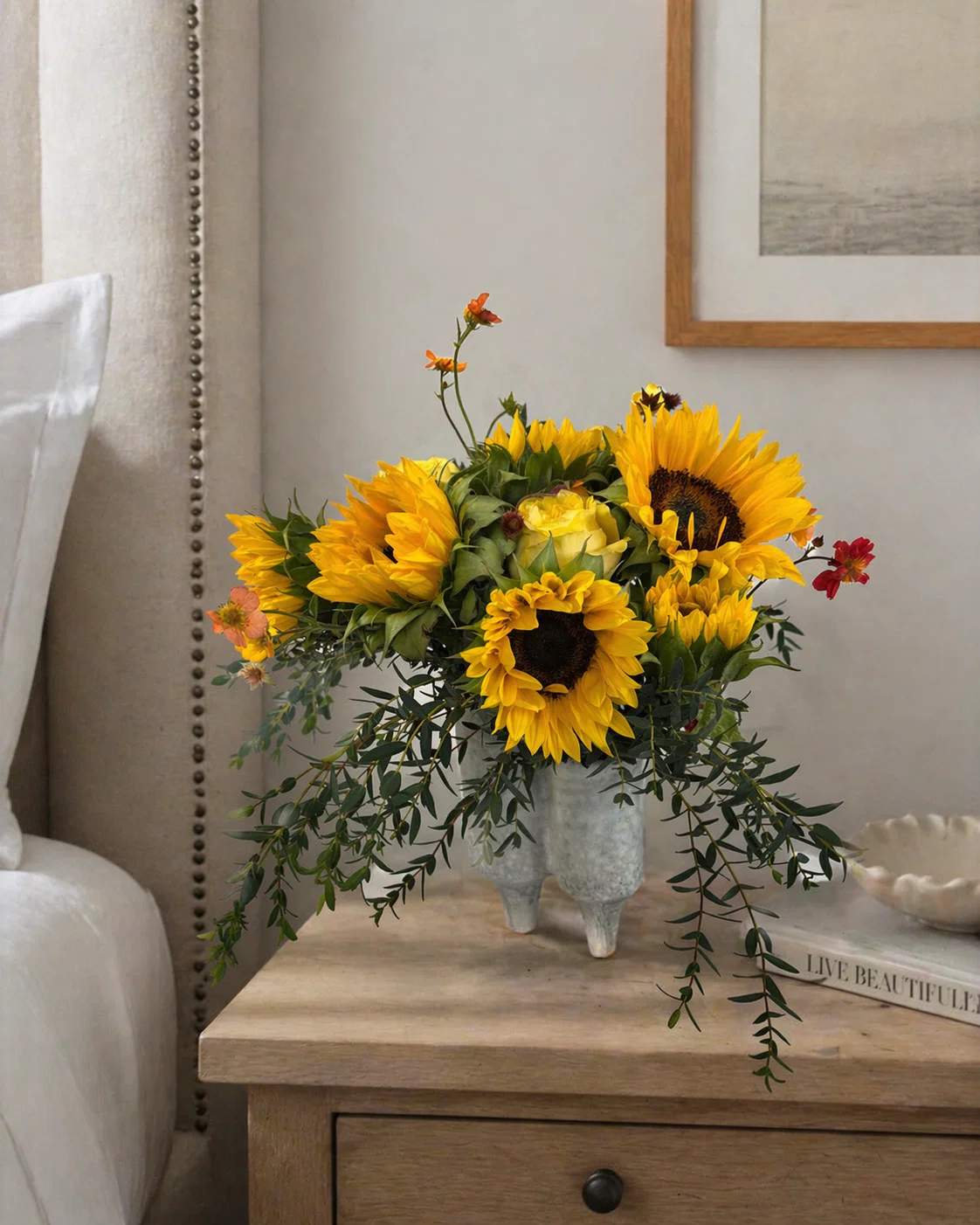 Sunflower arrangement in a textured vase on a bedside table