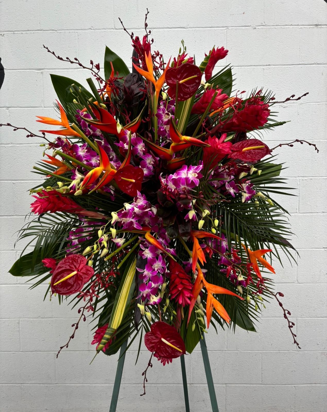 Large tropical floral spray with red anthuriums, orchids, and orange bird of paradise