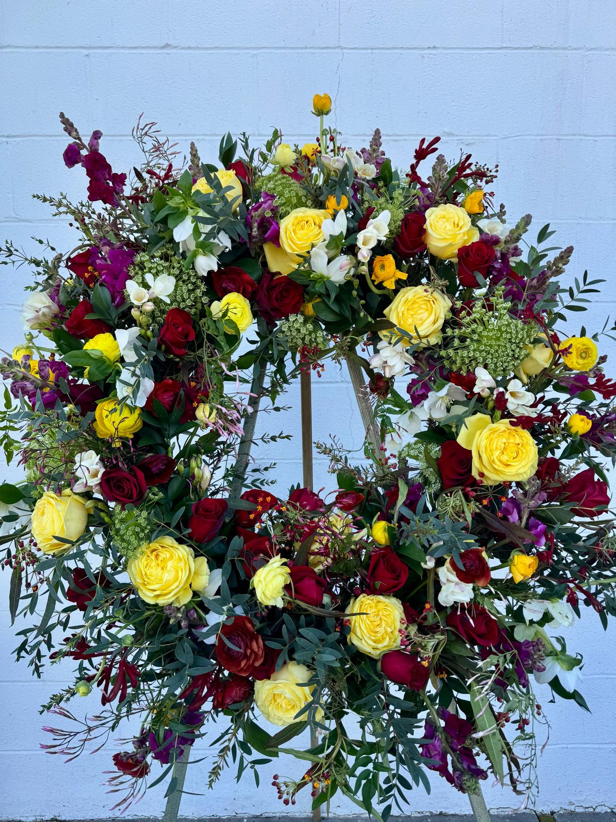Large floral wreath with yellow, red, white, and purple flowers