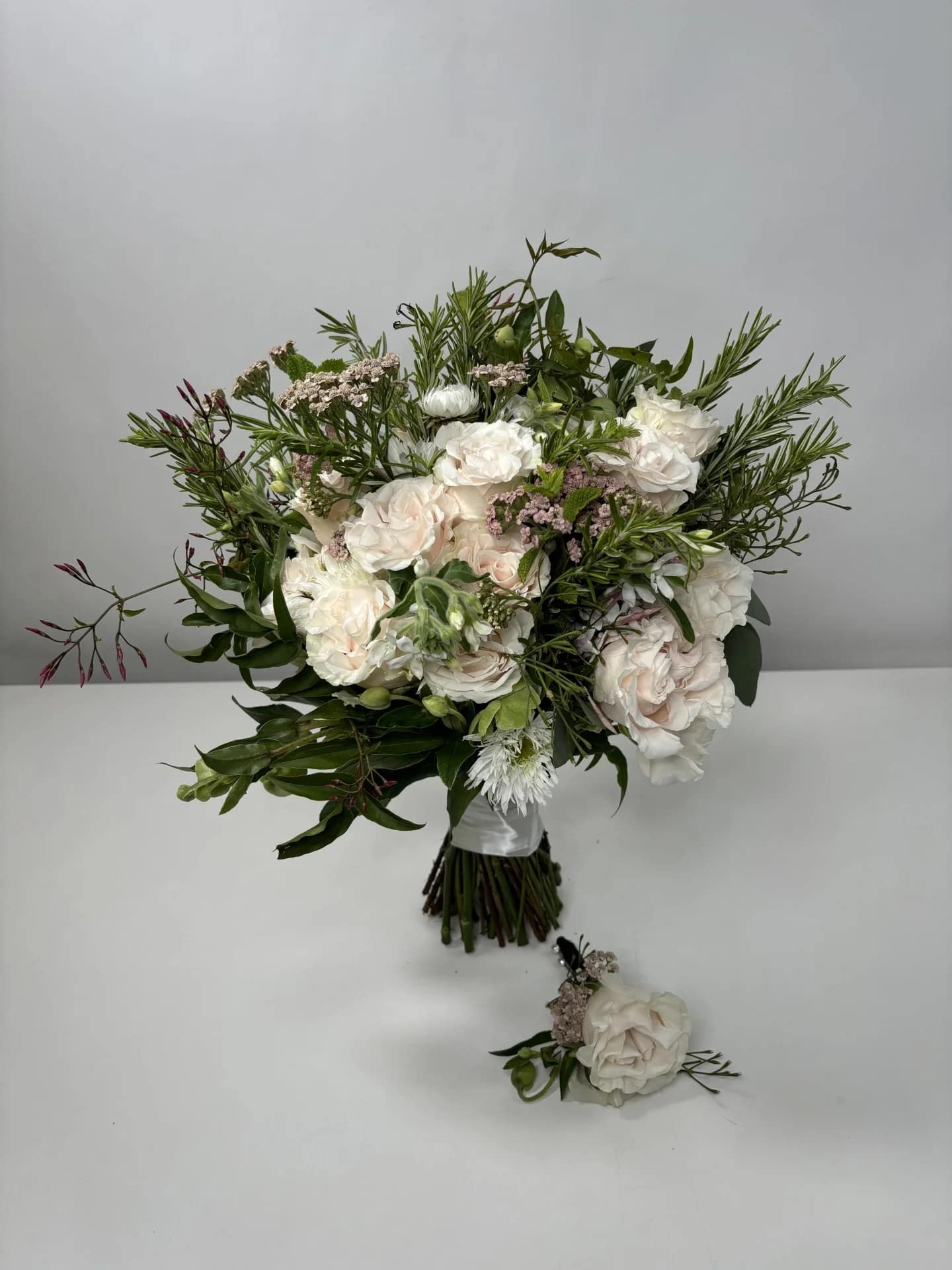 White and blush bouquet with greenery and a matching boutonniere