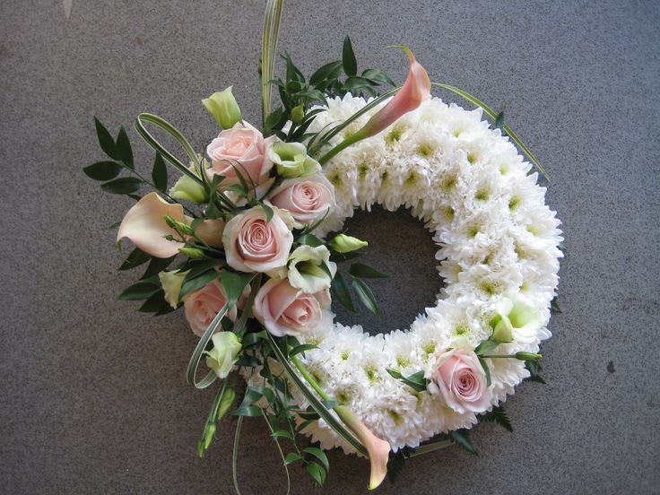 Circular floral wreath with white chrysanthemums, pale pink roses, and calla lilies