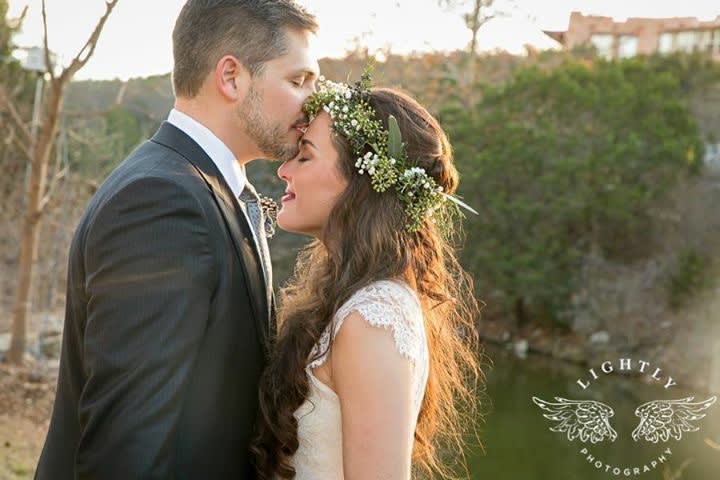 Bride and groom in an outdoor kiss, with a floral crown on the bride