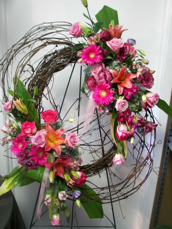 Two floral wreaths with pink and orange flowers on a wire frame