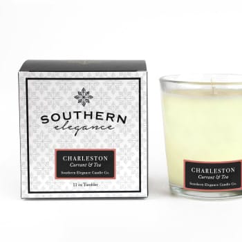 Boxed candle beside a glass jar candle labeled Charleston Currant &amp; Tea