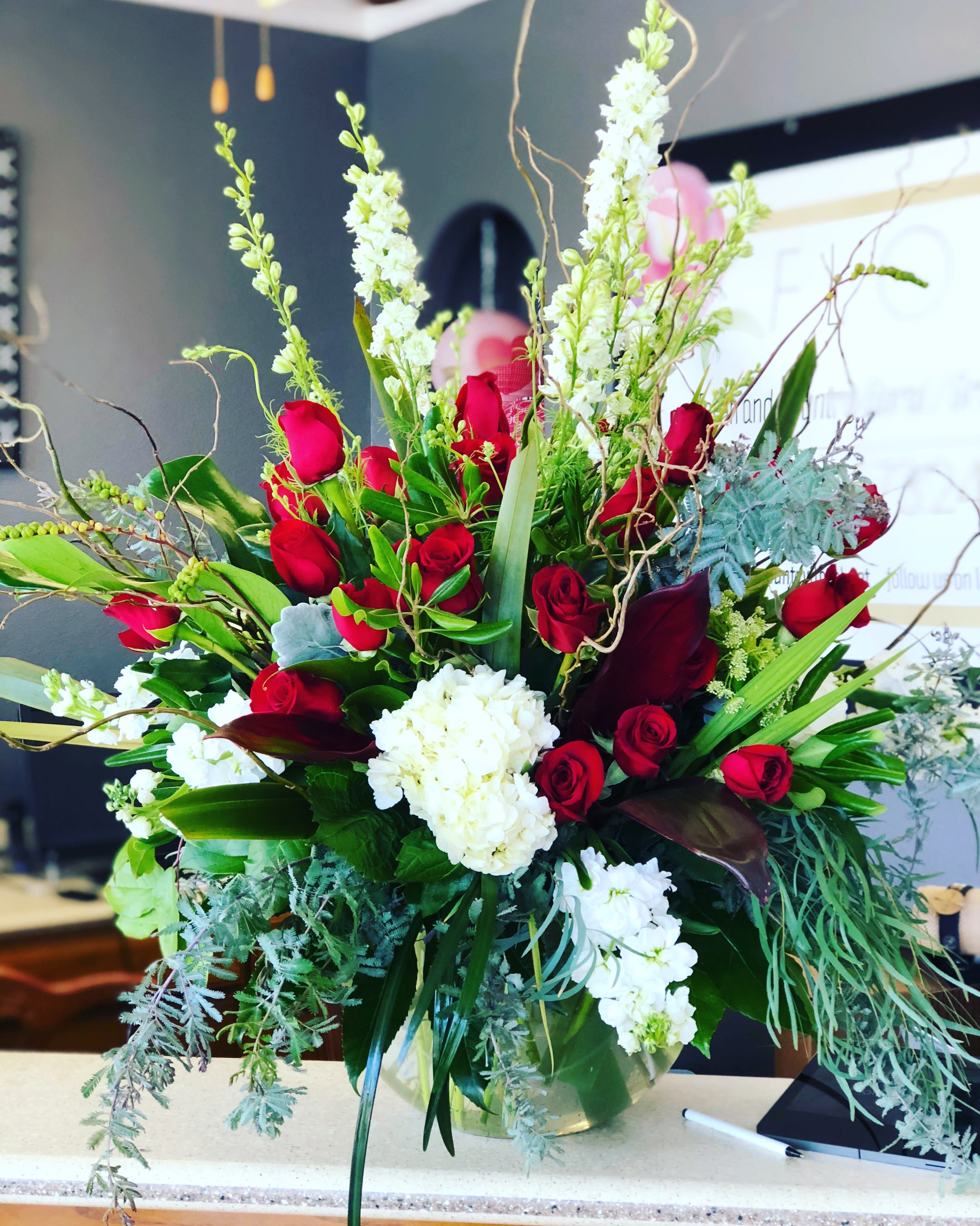 Large bouquet of red roses and white flowers in a glass vase