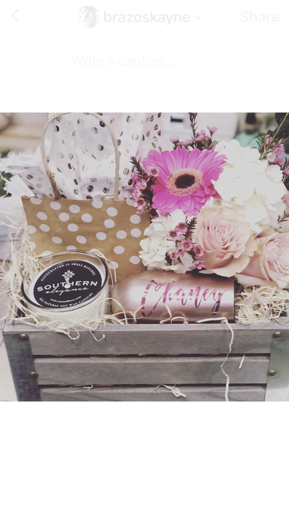 Gift basket with pink flowers, a candle, and a tumbler