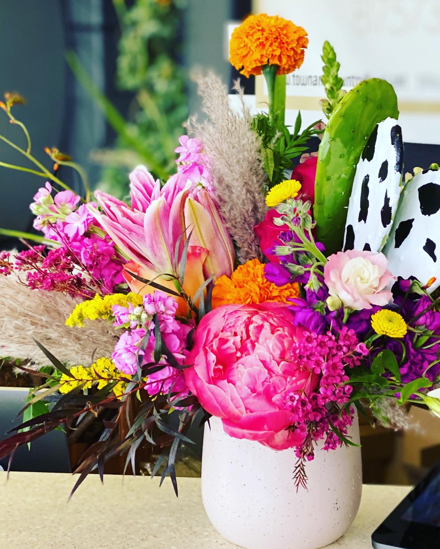 Colorful mixed bouquet in a white vase with pink and orange blooms