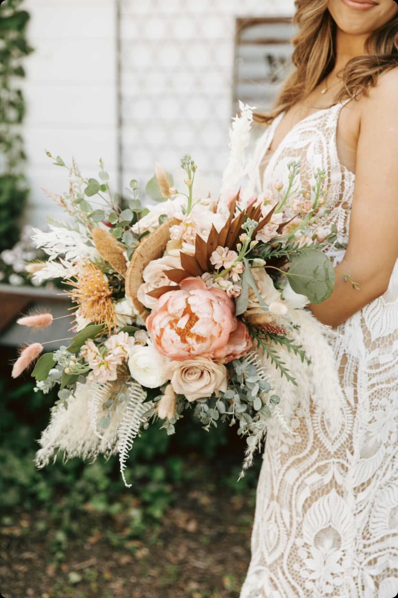 Bride holding a large peach and white bouquet