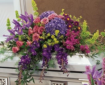 Colorful casket spray with pink roses and purple flowers