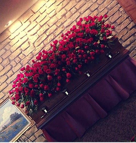 Large arrangement of red roses displayed on a mantel