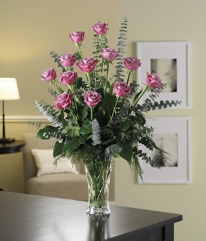 Pink roses in a clear glass vase with eucalyptus