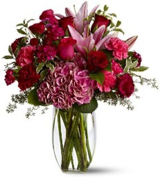 Bouquet of red and pink flowers in a clear glass vase