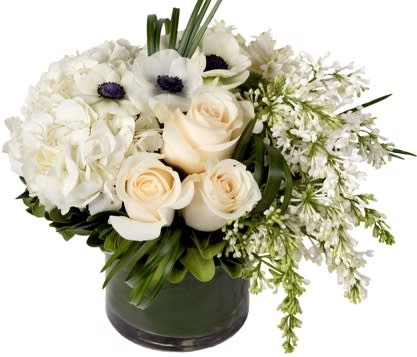 White floral arrangement with roses and anemones in a dark vase