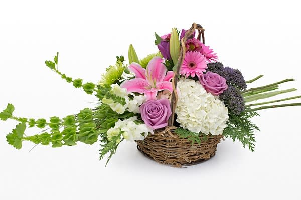 Basket arrangement with pink lilies, roses, and white hydrangeas