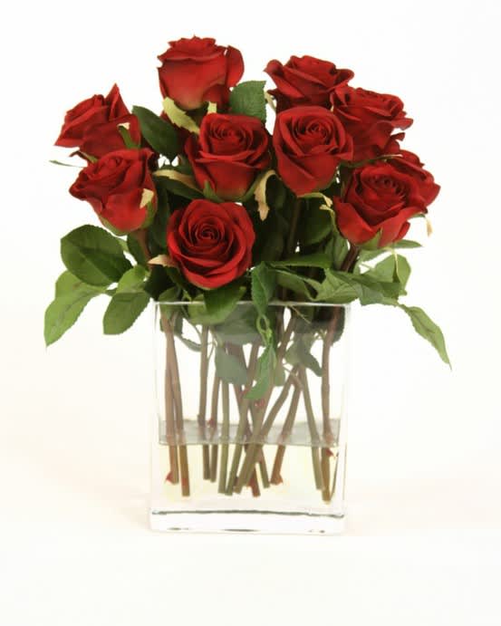 Red roses arranged in a clear glass vase