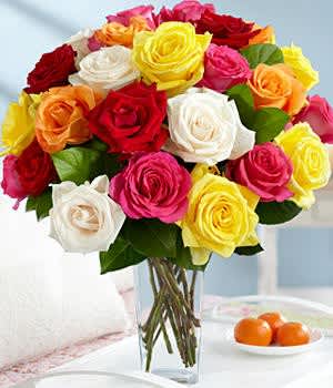 Bouquet of multicolored roses in a clear glass vase