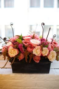Pink and cream rose arrangement in a black rectangular container
