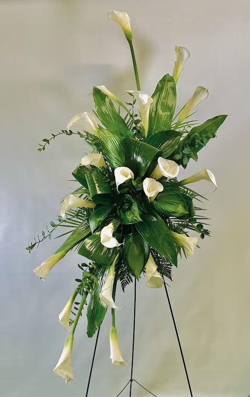 Tall arrangement of white calla lilies on a black stand