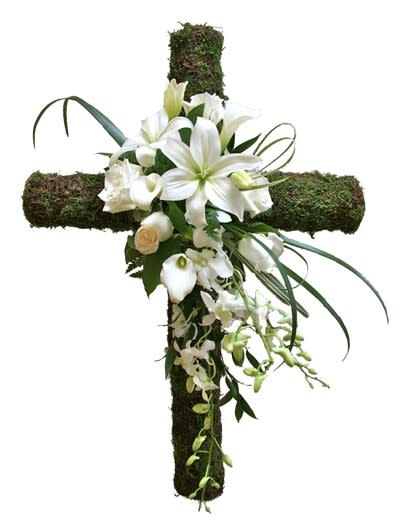 White flowers arranged on a moss-covered cross