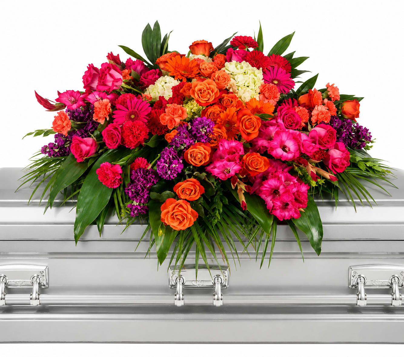 Pink Elegant Tribute Casket Spray - A vibrant, full-coverage casket spray that brings warmth and celebration to a sympathy service, this funeral arrangement combines pink, purple, orange and white blooms to honor a life with color and grace. As a casket spray, it's designed to rest across the lid and create an immediate, uplifting focal point-perfect for a memorial where friends and family want to express affection and remembrance.  Tightly layered roses, carnations, gerbera daisies and chrysanthemums form the lush, dense top while broad greenery frames the edges for a softly cascading silhouette. The silver casket hard good complements the saturated florals, letting the pinks and purples sing while oranges add unexpected brightness. Generous in scale and assembled for a polished, lasting presentation, this piece reads as both reverent and celebratory.  For a sympathy or funeral service, this spray says you want the person remembered with warmth and color-the kind of tribute that makes mourners feel comforted and seen. Arrives ready to place on the casket; standard care is minimal when displayed indoors for the service, but our florists prepare the foam and wiring to ensure the arrangement stays secure and fresh through the ceremony.