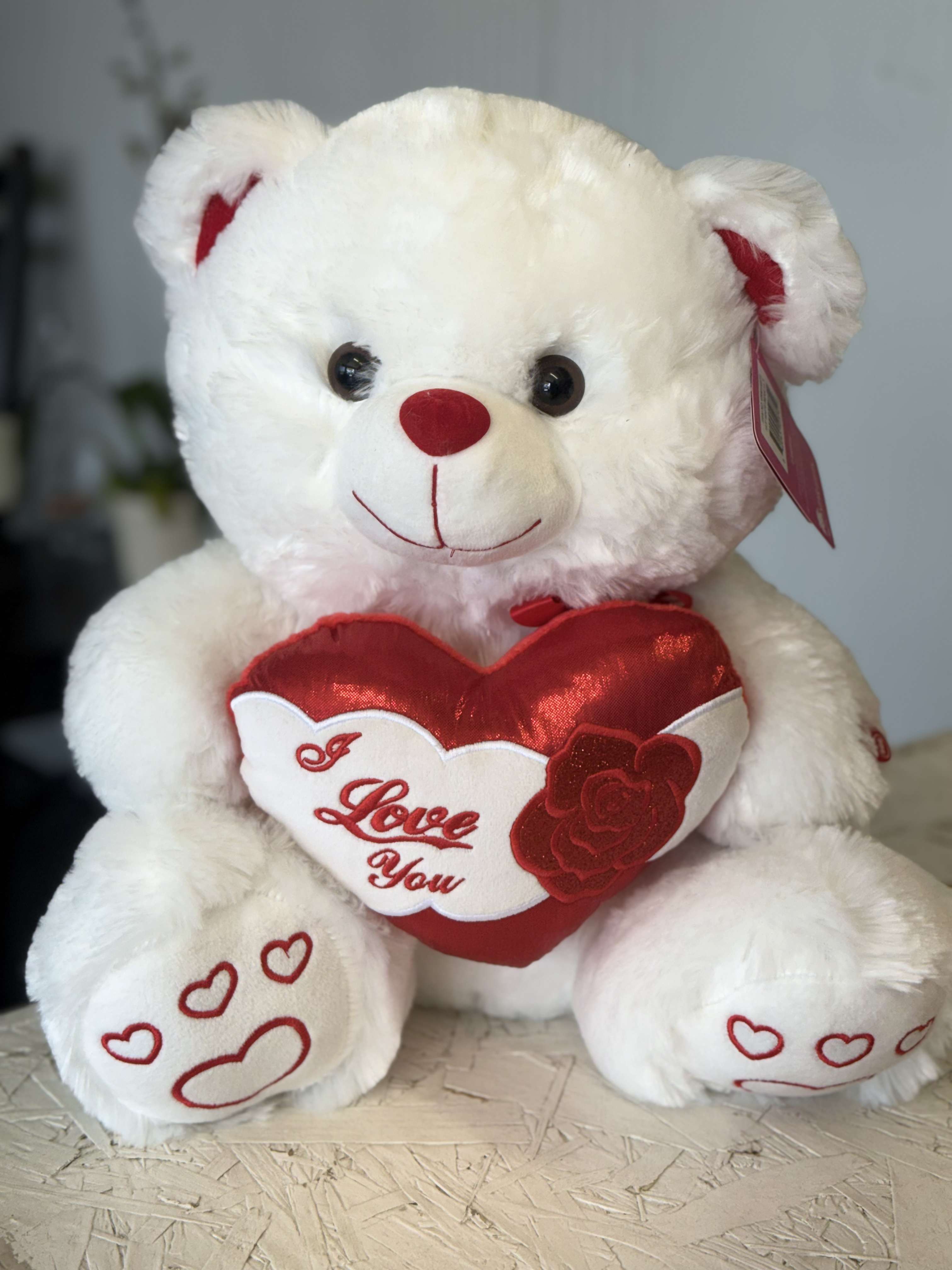 White teddy bear holding a red heart that says I Love You