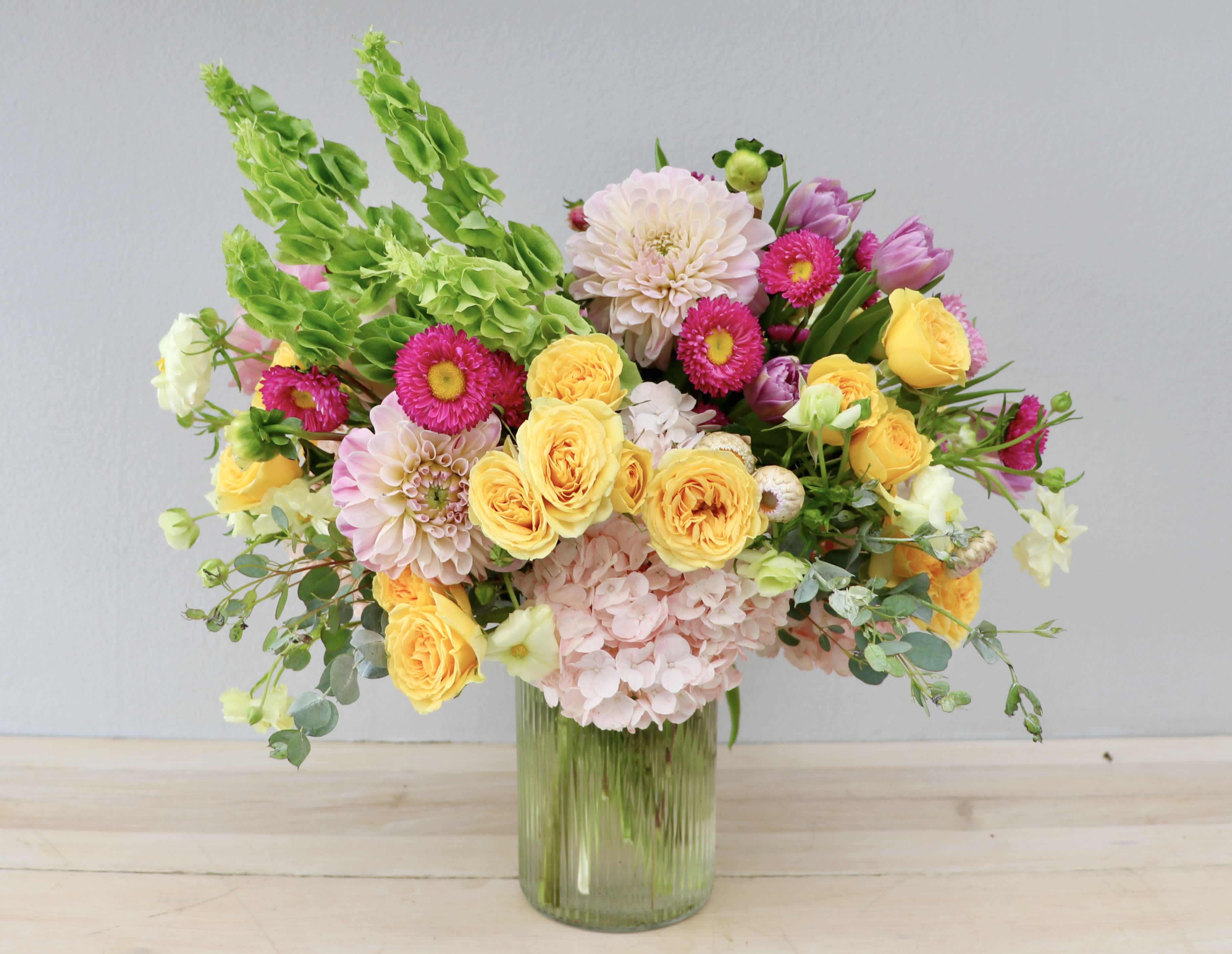 Mixed bouquet of yellow and pink flowers in a glass vase