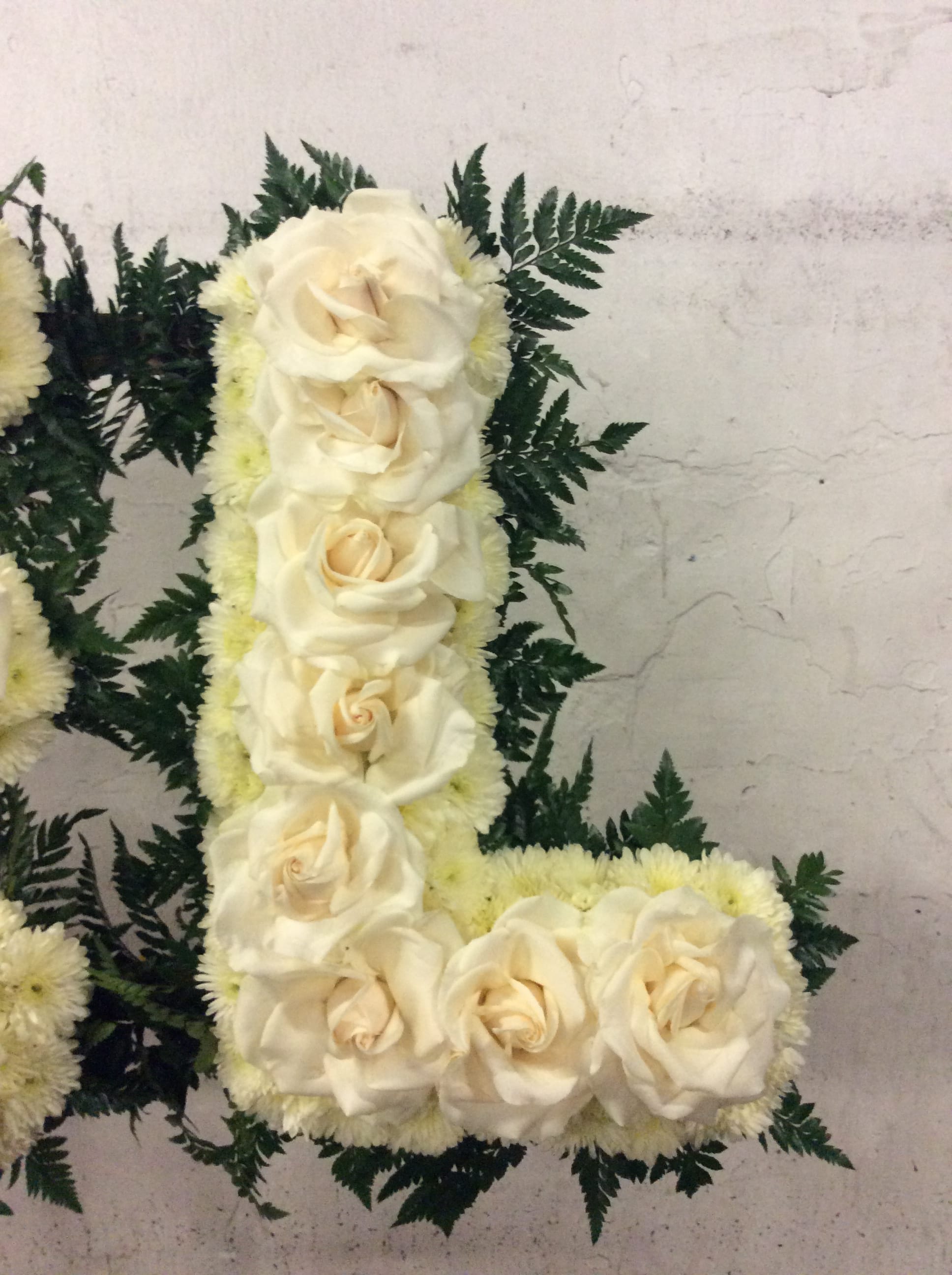 White rose floral arrangement with dark fern foliage