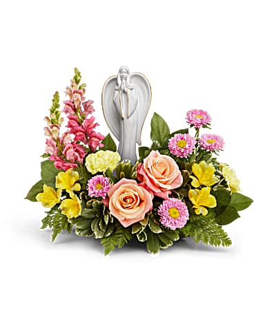 Pink and yellow floral arrangement with an angel figurine