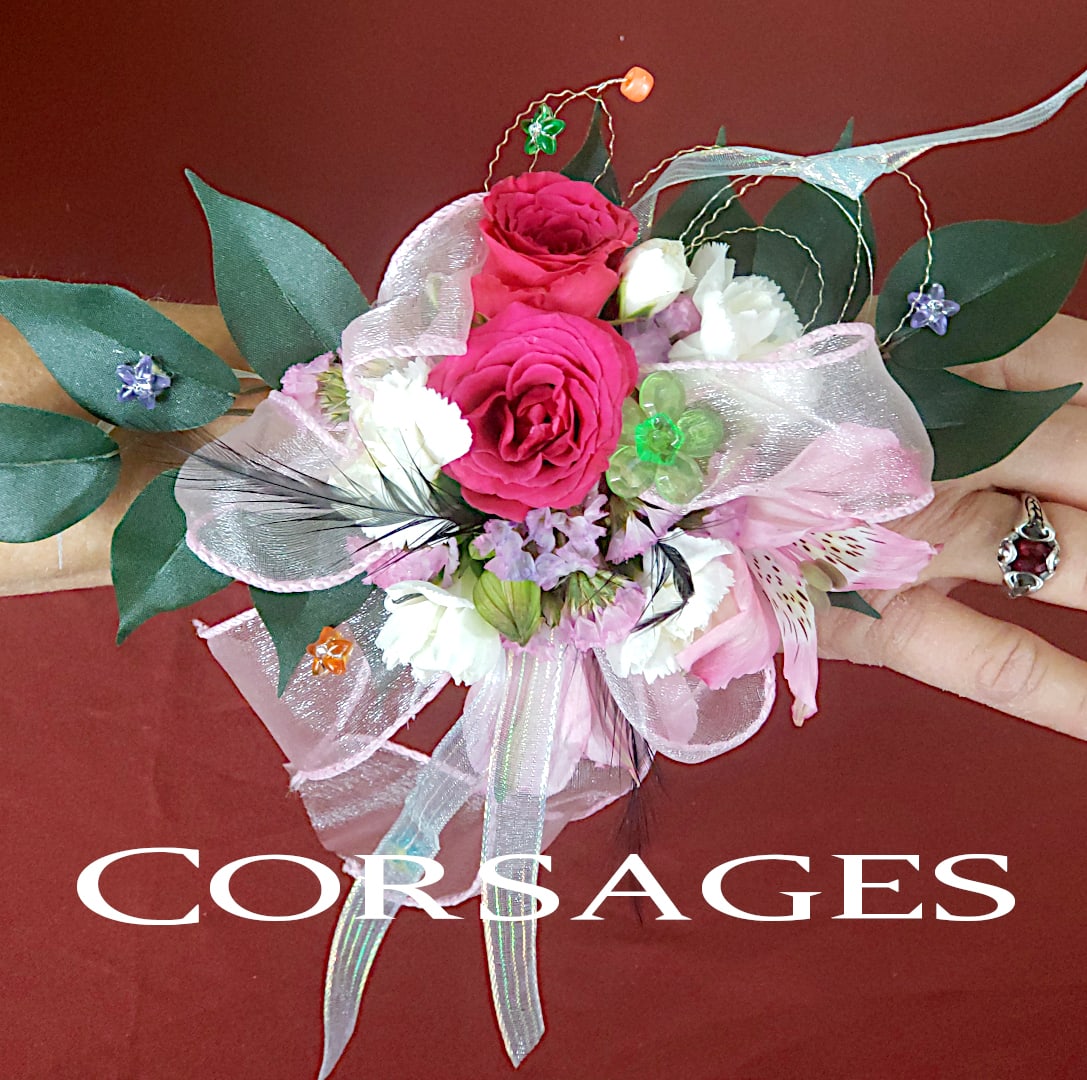 Pink and white floral corsage with ribbon and greenery