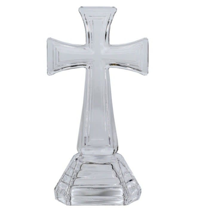 Clear glass cross-shaped decorative object on a white background
