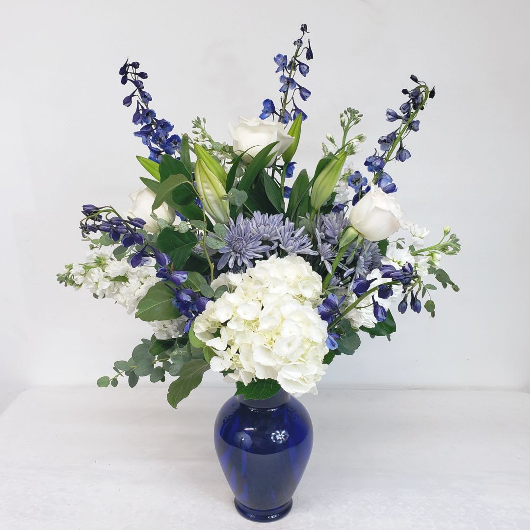 Blue and white floral arrangement in a cobalt vase