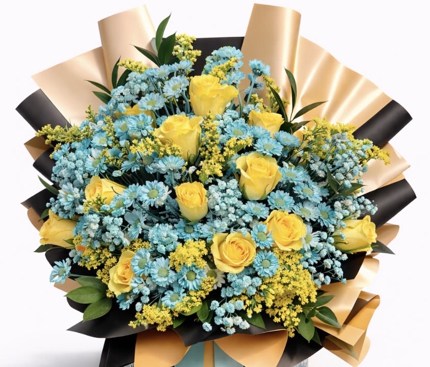 Bouquet of yellow roses and blue daisies wrapped in black and gold paper