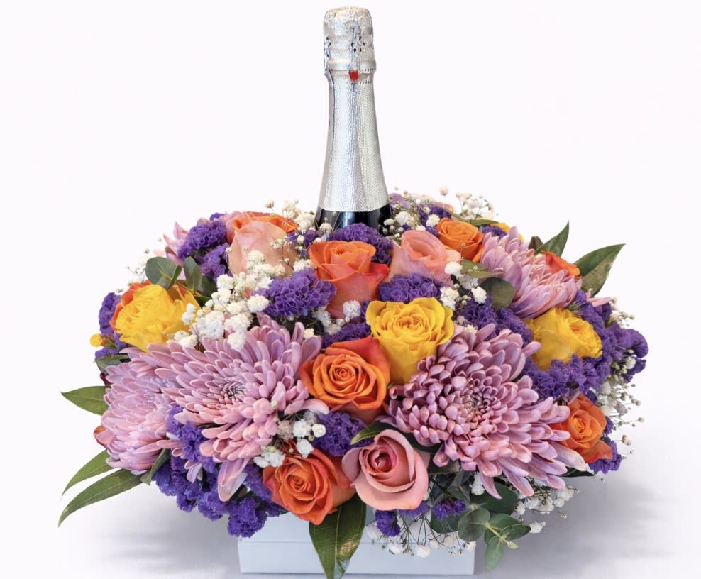 Mixed bouquet with roses and purple chrysanthemums around a champagne bottle