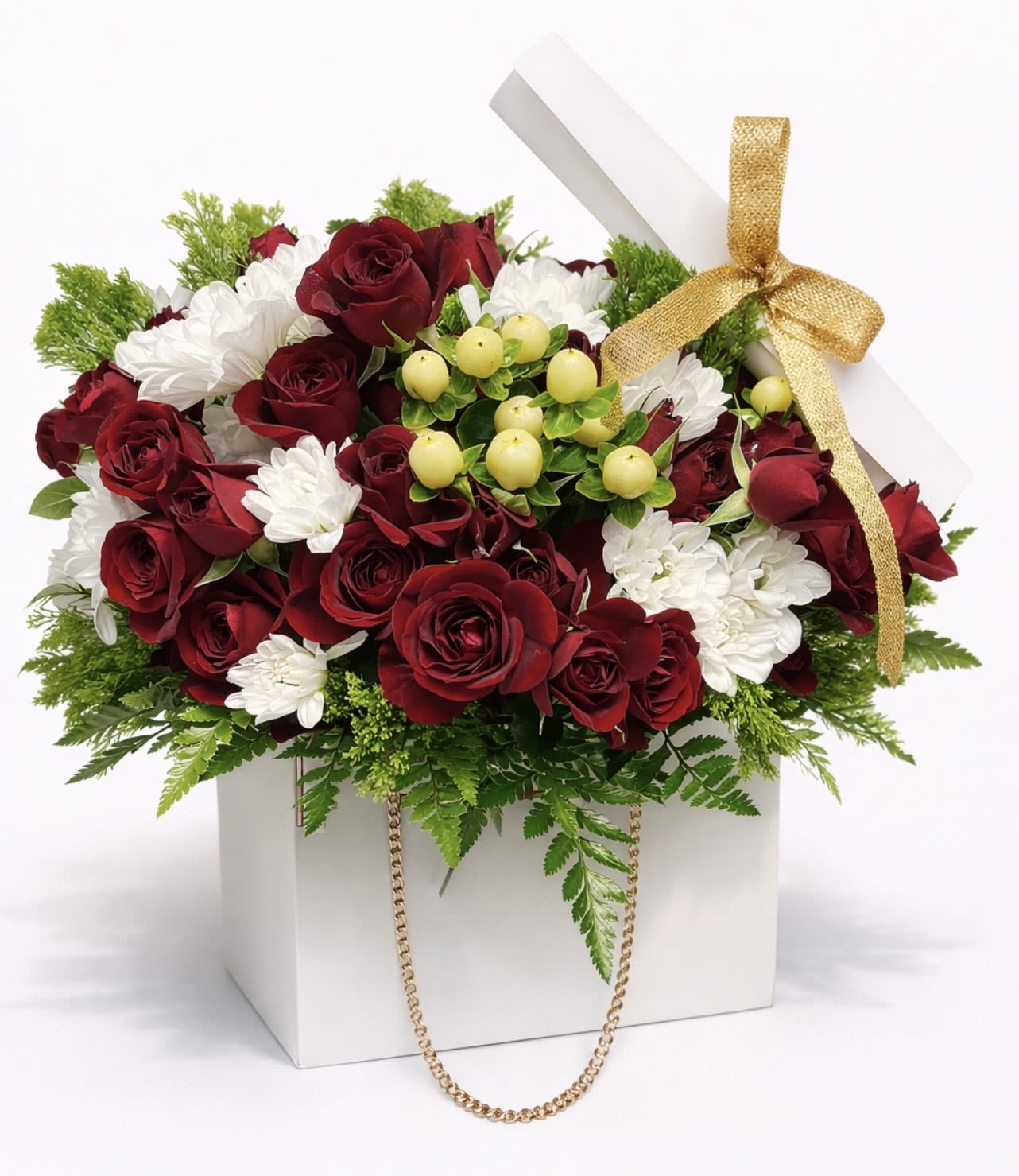 Red roses and white daisies in a white gift box with a gold ribbon