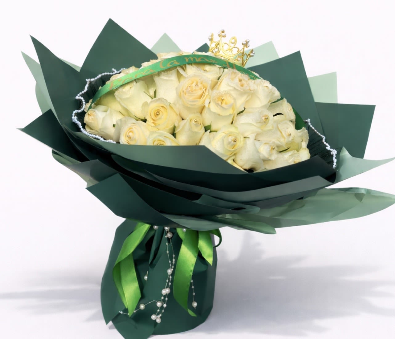Crowned in Success - A majestic and elegant bouquet crafted with ivory roses, beautifully arranged and wrapped in sophisticated emerald-green paper. Accented with satin ribbons, delicate decorative details, and a subtle golden touch that symbolizes success, excellence, and new beginnings. A refined and meaningful gift, perfect for celebrating graduation and honoring hard work, dedication, and achieved dreams.