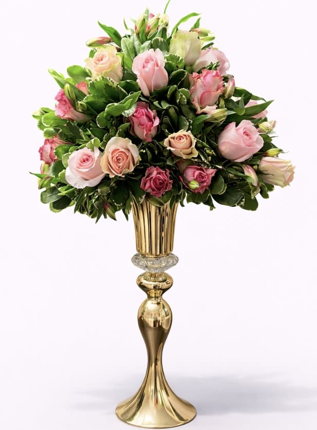 Pink and cream roses arranged in a tall gold vase
