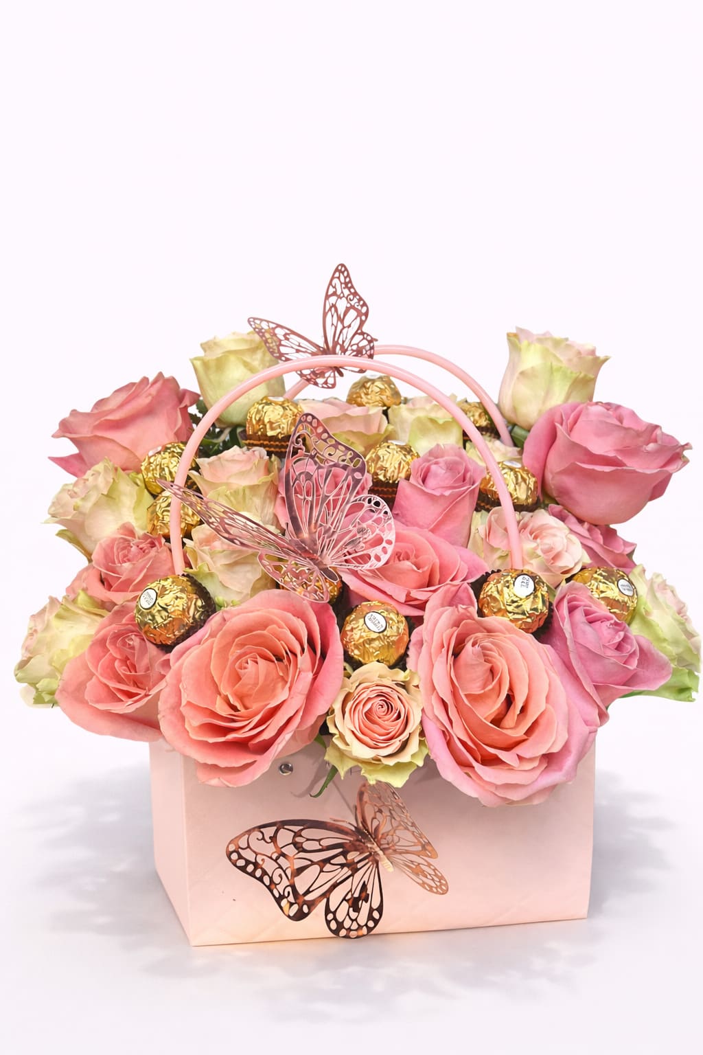 Pink and cream roses in a pale pink gift box with butterfly decorations