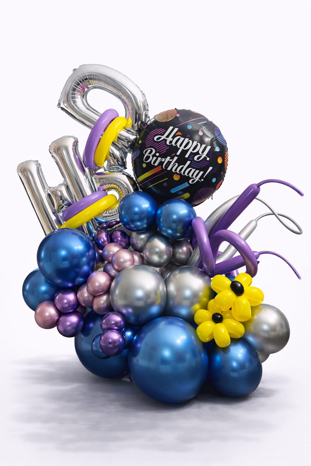 Birthday balloon arrangement with metallic number balloons and a "Happy Birthday" balloon