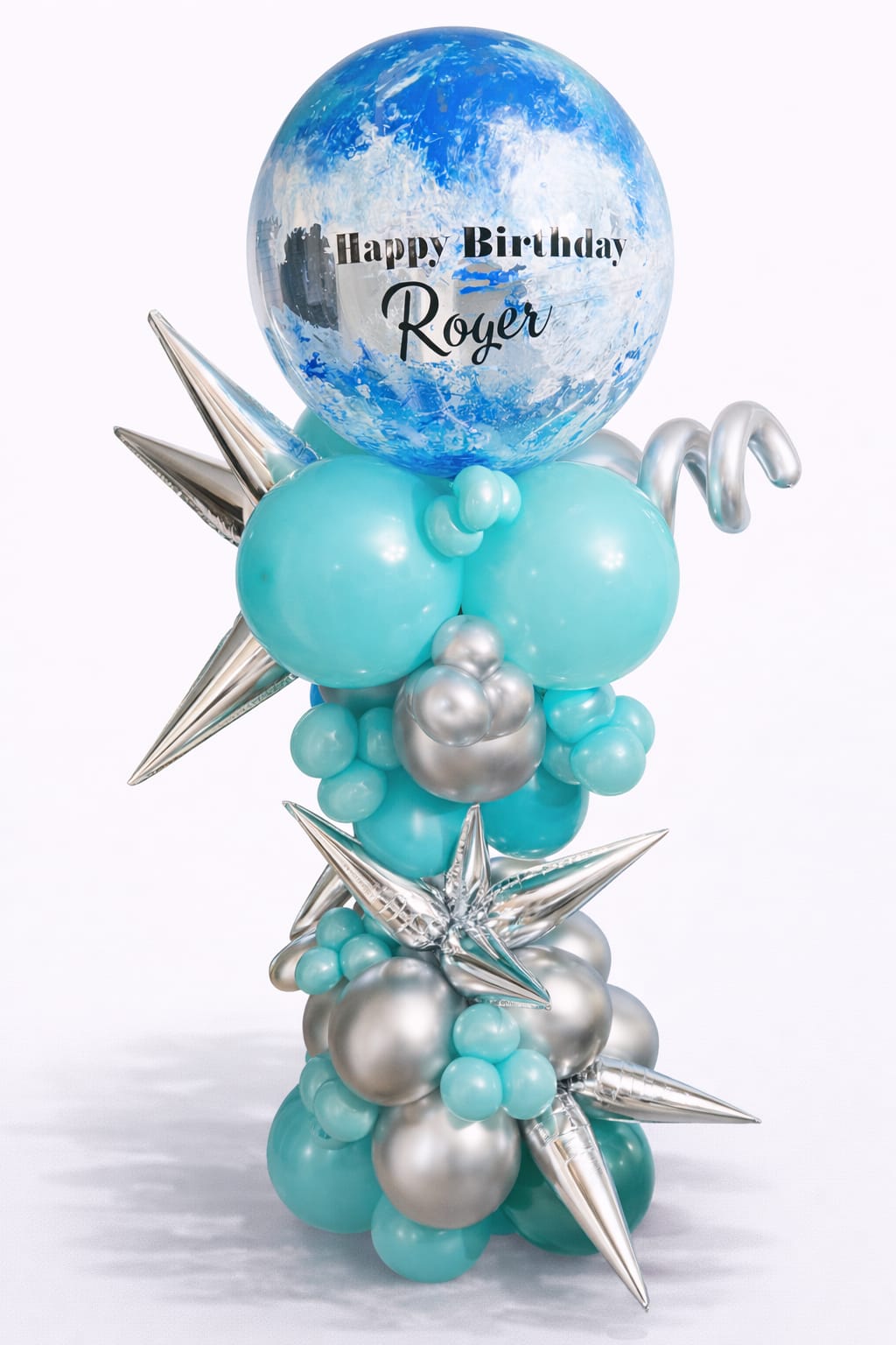 Tall birthday balloon arrangement in blue and silver with a large printed topper and star accents.