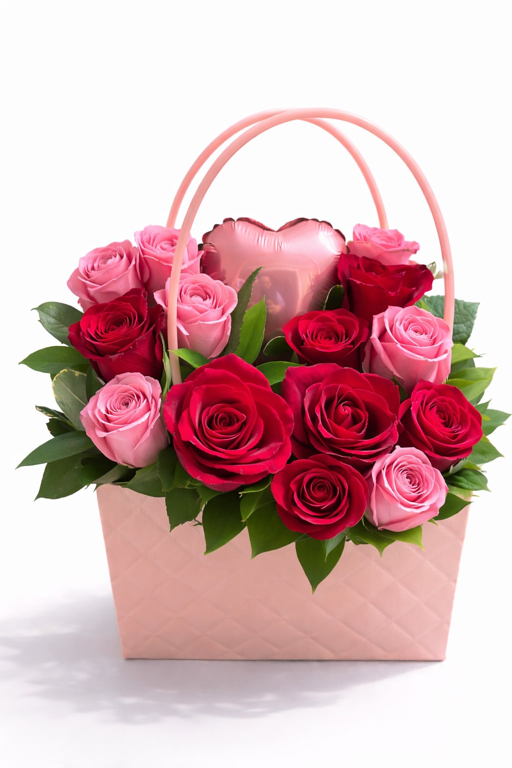 Pink and red roses arranged in a pink gift basket with a heart balloon