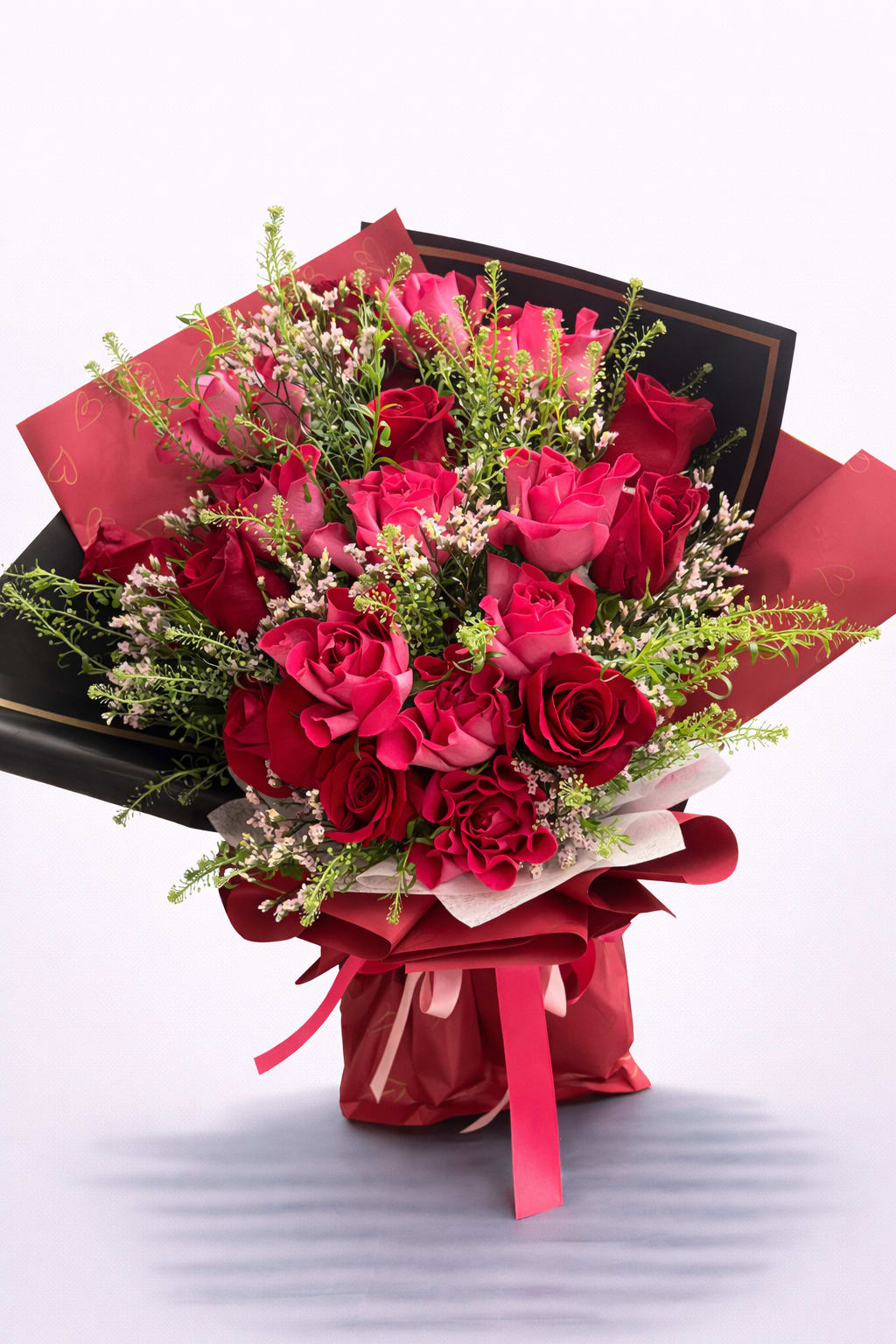 Bouquet of pink and red roses wrapped in black and red paper