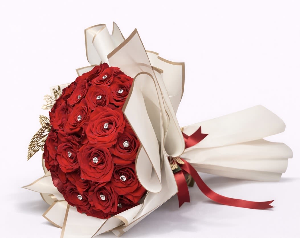 Bouquet of red roses wrapped in cream paper with a red ribbon