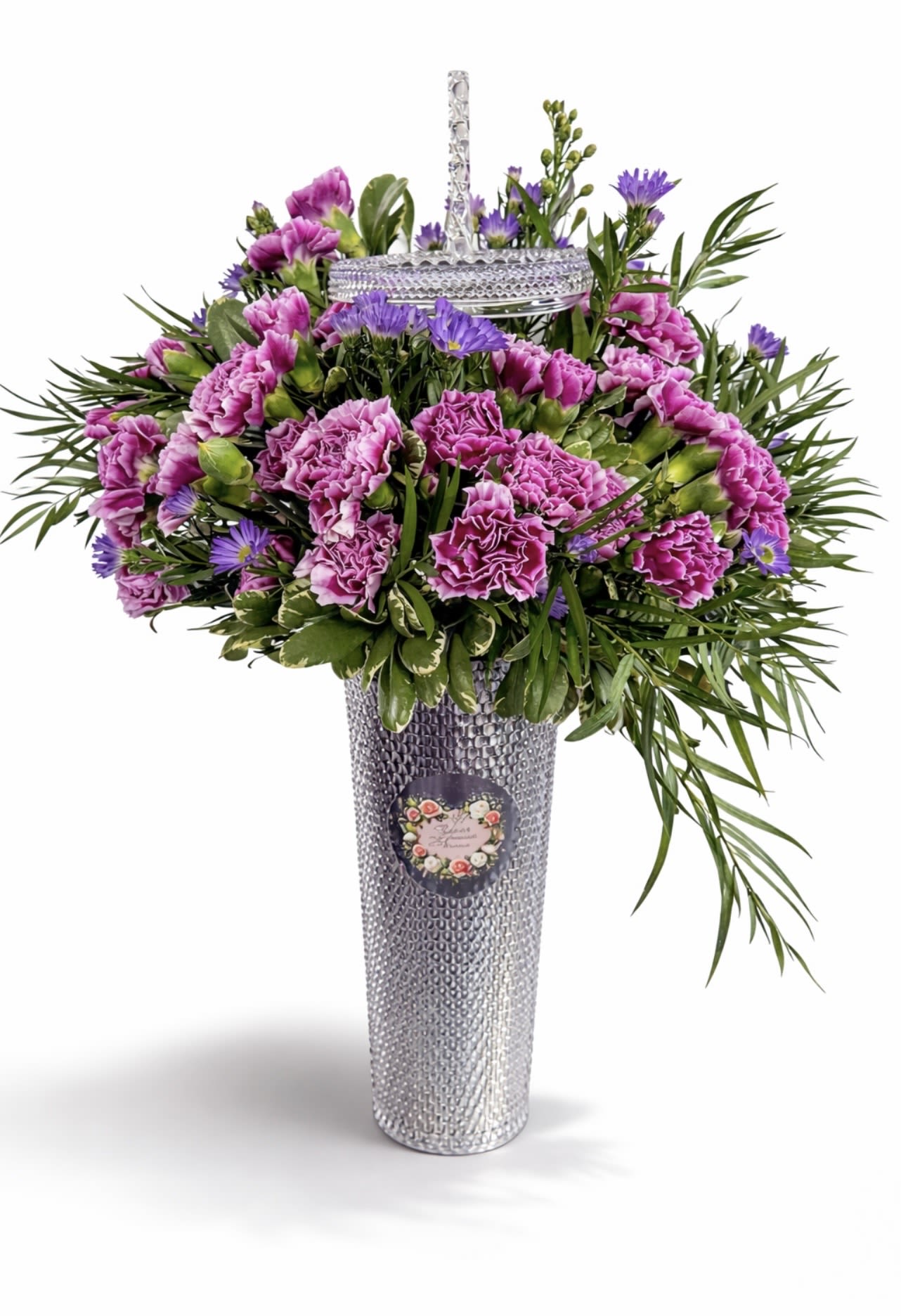 Purple carnations and daisies in a tall silver vase