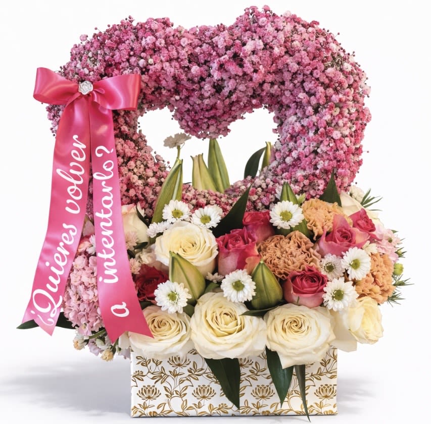 Heart-shaped pink floral arrangement with roses and a ribbon in a patterned box